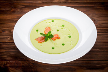 Green pea cream soup with salmon fillet