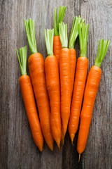 Fresh carrots bunch on rustic wooden background.