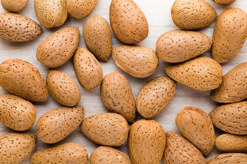 Group of almond nuts with leaves.Wooden background.