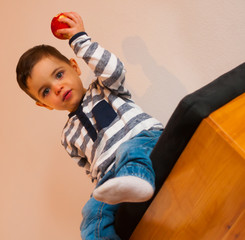 Kleiner Junge hält Apfel hoch