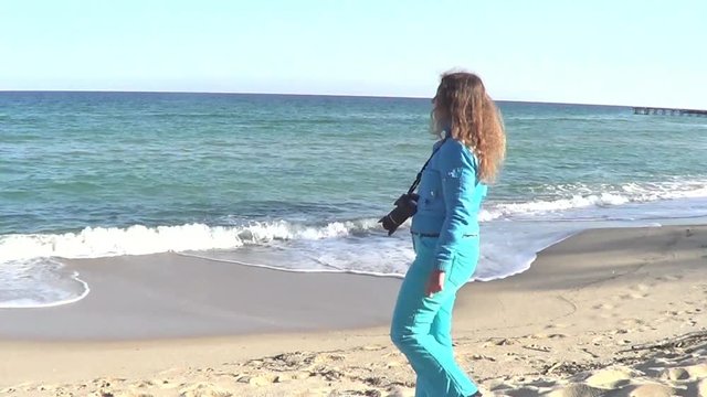 Woman recording sea on photo-camera
