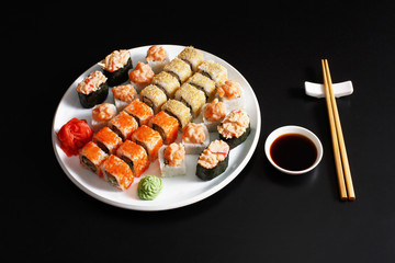 Set of sushi maki and rolls at black background