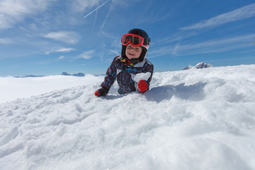 Fototapeta na wymiar Roztomilý malý lyžař a alpské panorama.