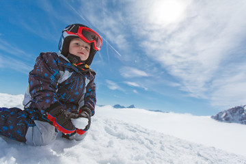 Fototapeta na wymiar Roztomilý malý lyžař a alpské panorama.