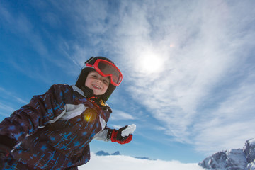 Roztomilý malý lyžař a alpské panorama.