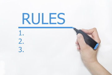 Hand underlining Rules with red marker on transparent wipe board.