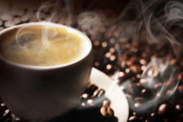 Cup of coffee and grains, closeup