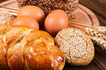 Assortment of baked bread on wooden table background