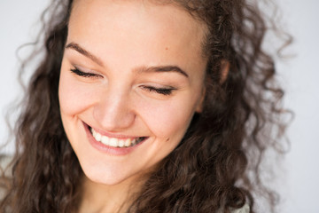 Happy smiling young woman face with closed eyes.Close-up portrait