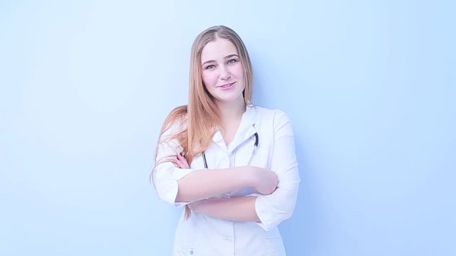 Young girl doctor smiling on a light background.