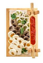 assorted meat rolls on a wooden platter isolated on white backgr
