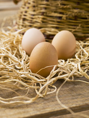three brown eggs on a wooden table
