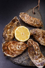 Oysters first size and yellow lemon on the rock. fresh raw gourmet seafood