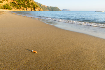 Cigarette butt sandy beach