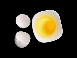 broken eggshell with yolk in bowl