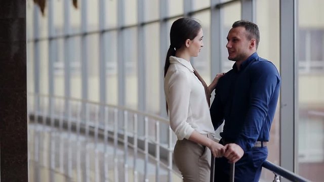 Portrait of young happy couple with baggage looking at one another in airport