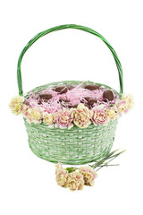 Fototapeta na wymiar chocolate egg shape in basket with pink confetti and flower