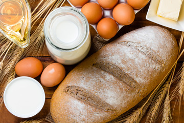 Ingredients for homemade bread and breakfast laid out on wooden table in rustic kitchen