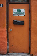 Old creepy door with no trespassing sign