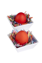 two red easter eggs on a white bowl