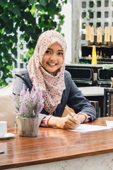 businesswoman working while having a break on a cafe