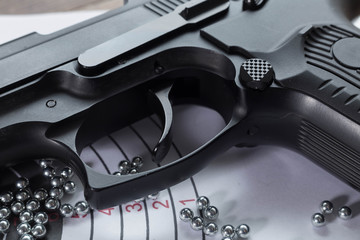 Trigger pneumatic gun and bullets closeup on the target
