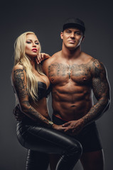 Fototapeta na wymiar Modern tattooed couple posing in a studio.