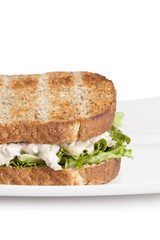 cropped image of egg salad sandwich in white plate