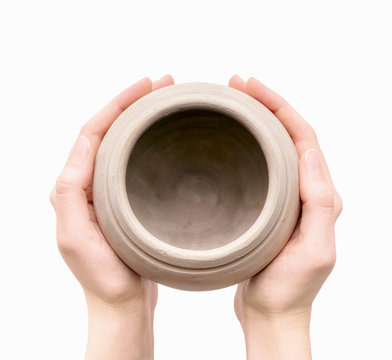 Unburnt clay pot in a woman's hands