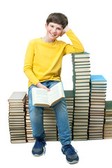 Young boy sitting on stacks of books and reading - 107204913