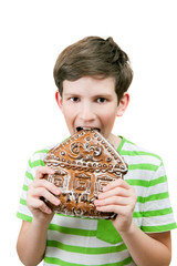 the boy eats a big gingerbread
