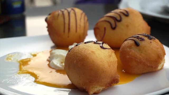 Eating fried banana and ice cream balls topping with chocolate dessert