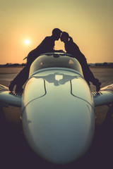 Fototapeta na wymiar Silhouette of couple pilot is kissing on a small jet. - (Selecti