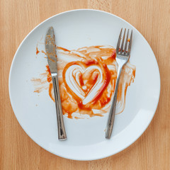 Knife and fork over in finish plate and heart shape ketchup, con