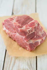 raw pork neck meat on wooden table