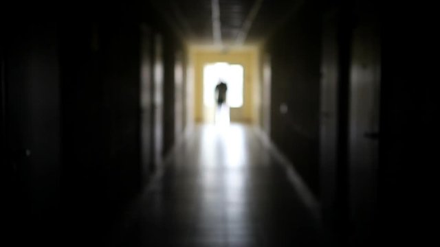 The silhouette of a man goes through the dark corridor to a bright future. The Ghost of a businessman .The path to success.