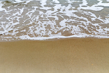 Fototapeta na wymiar Soft wave of the sea on the sand beach