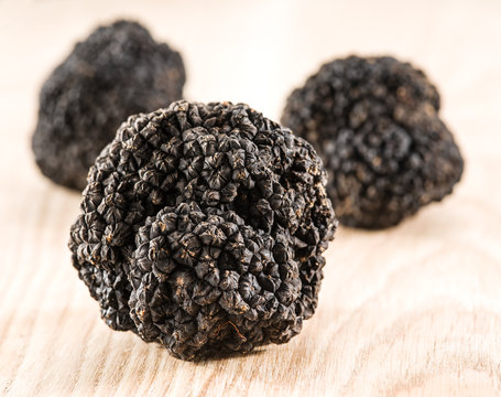 Black truffles on the old wooden table.