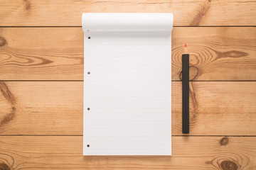 Notepad with pencil on a wooden desk 