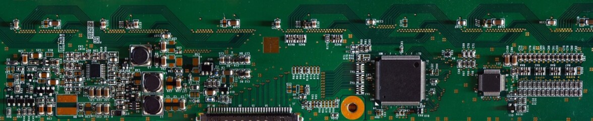 The board with radio elements. Part of the electronic device close up. Panorama of the electronics unit. On the green panel set of soldered electronic components. 