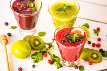 fresh berry smoothies. fruit cocktail with kiwi, currant, cranberry, lime, honey and mint. healthy eating. diet and detox concept.