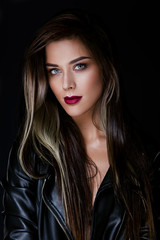 Glamour portrait of beautiful girl model with makeup and romantic wavy hairstyle. Fashion shiny highlighter on skin, sexy gloss lips make-up and dark eyebrows.