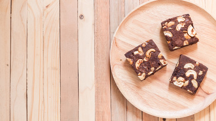Top view of chocolate brownie cake served on wooden plate.
