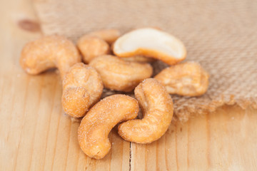 Pile of roasted cashew nuts on wood background