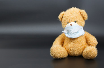 A plush teddy bear in a medical mask