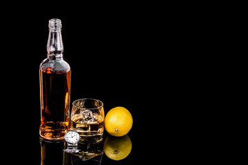 Bottle and glass whiskey and watch on black background