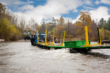 Fototapeta na wymiar Heavy truck for transportation of logs stuck in the river