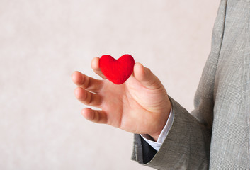 A red heart in a man's hand.Closeup