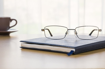 Glasses and a book on the desk