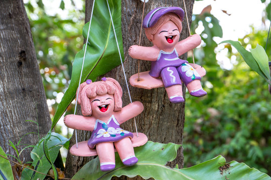 Two ceramic doll mobile hanging on the tree